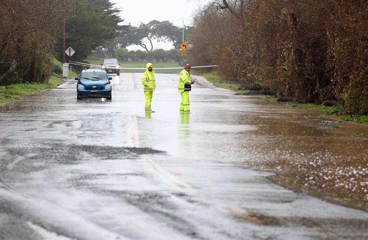 SLO County workers check the flooding on Windsor Boulevard near Santa Rosa Creek in Cambria on Thursday.