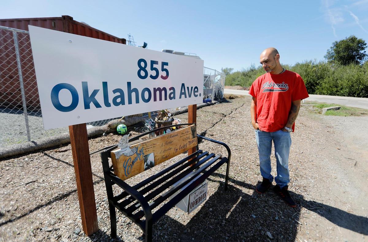 Juan Mejia looks at a bench that he built to honor his friend, Cowboy, who passed away recently. He commented that someone stole cowboy boots placed on the bench at the Oklahoma Avenue Safe Parking Site.