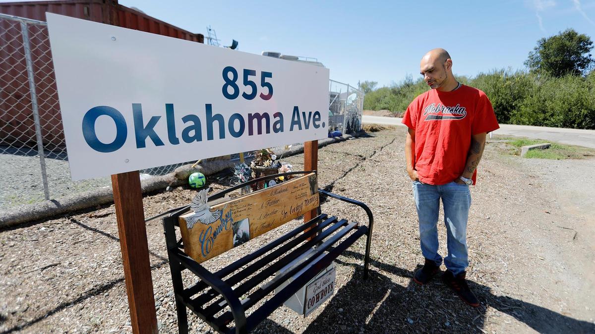 Juan Mejia looks at a bench that he built at the Oklahoma Avenue Safe Parking Site in 2022 to honor his friend, Cowboy, who had died.