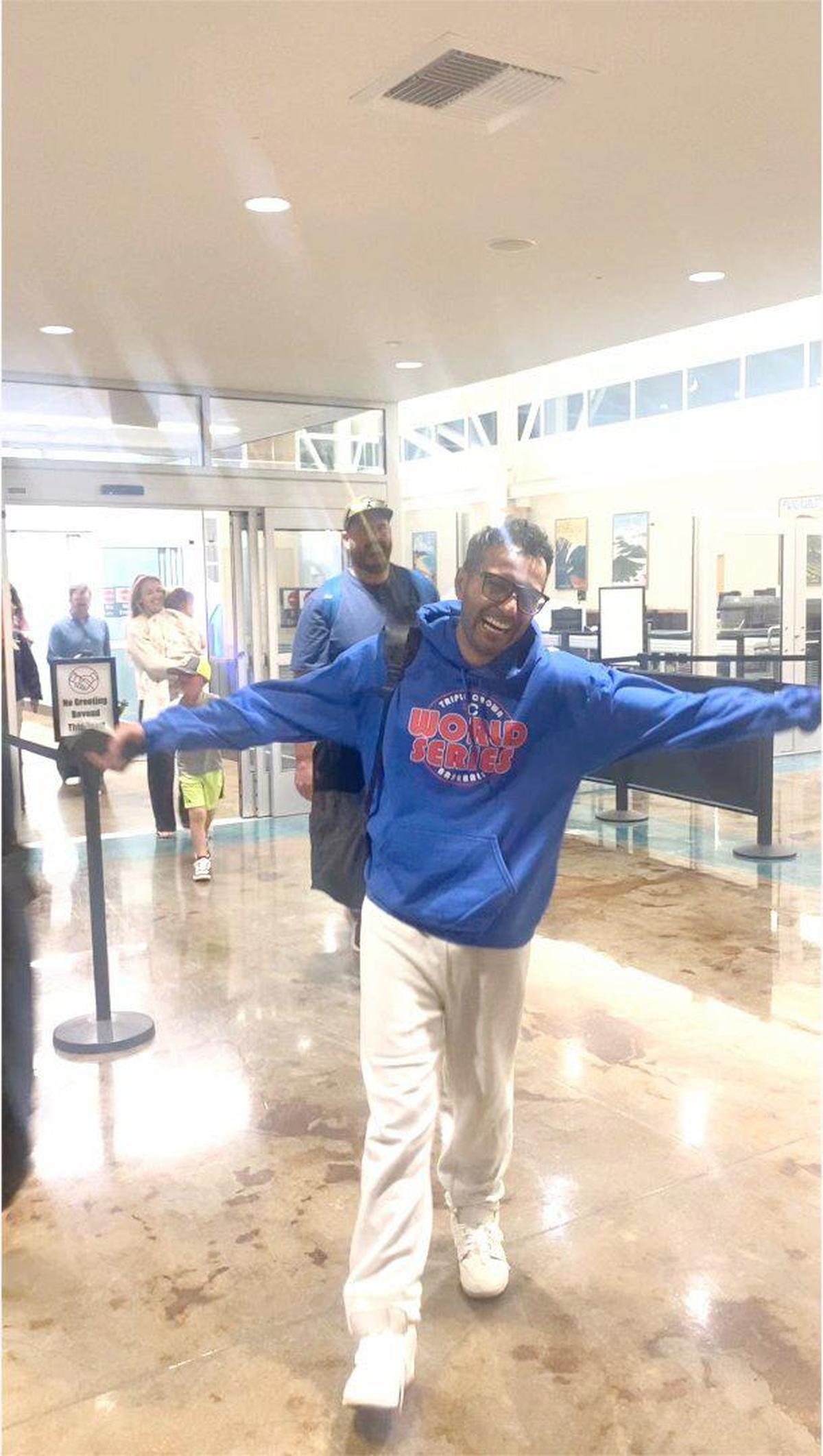 Ali Al-Shammari has arms outstretched in this picture from video as Michael Reeves says, “Welcome home!” at the airport after being released from immigration custody.