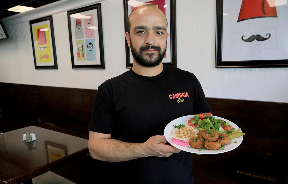 Classic Mediterranean food is the focus at the recently reopened Cambria Caf, which has a new owner, crew and cuisine. Owner Rafael Manja poses with plate of gyros.