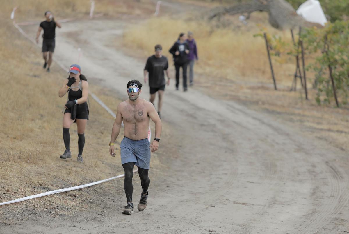 Exhausted participants walk on the last portion of the Spartan race held in Santa Margarita on Saturday, Nov. 2, 2024, featuring a variety of obstacles and courses of different challenge levels.