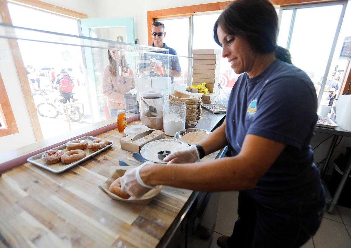 Ben and Jessica Brown acquired a shuttered former fish smokehouse in Cayucos and transformed it into a new, eye-catching doughnut shop. Jessica Brown prepares some freshly made doughnuts for customers.
