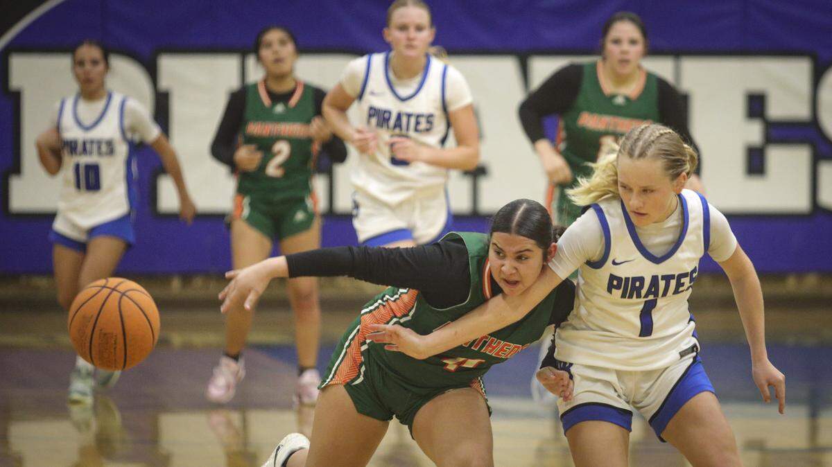 Alexa Garcia, left, and Emily Cordes strive to control a turnover. Morro Bay beat Porterville 37-25 to advance to the semi-final game in the Division III CIF Central Section Girls Basketball Championships.