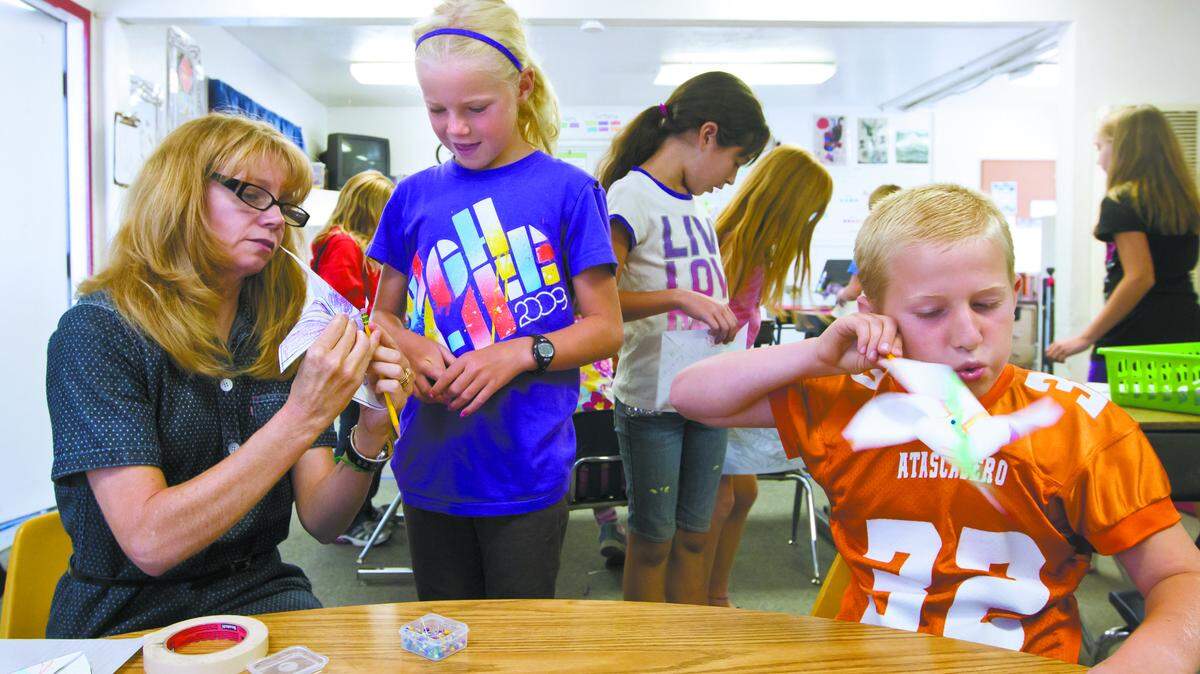 Art teacher Tisha Smith, left, helps Dana Weatherby, 9, with her pinwheel as Noah Rodrigues, 9, right, tries out his in September 2012. Students at North County Christian School made Pinwheels for an installation in the Atascadero Sunken Gardens called “Pinwheels for Peace.”