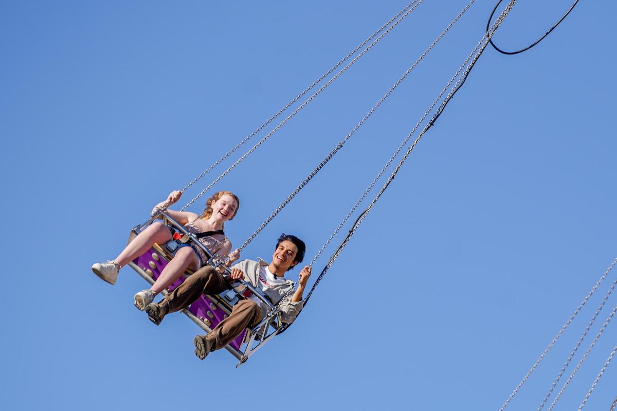 Tribune news interns Sasha Tuddenham, left, and Angel Corzo ride swings at the California Mid-State Fair on Wednesday, July 16, 2025. The Mid-State Fair will run from July 16-27.