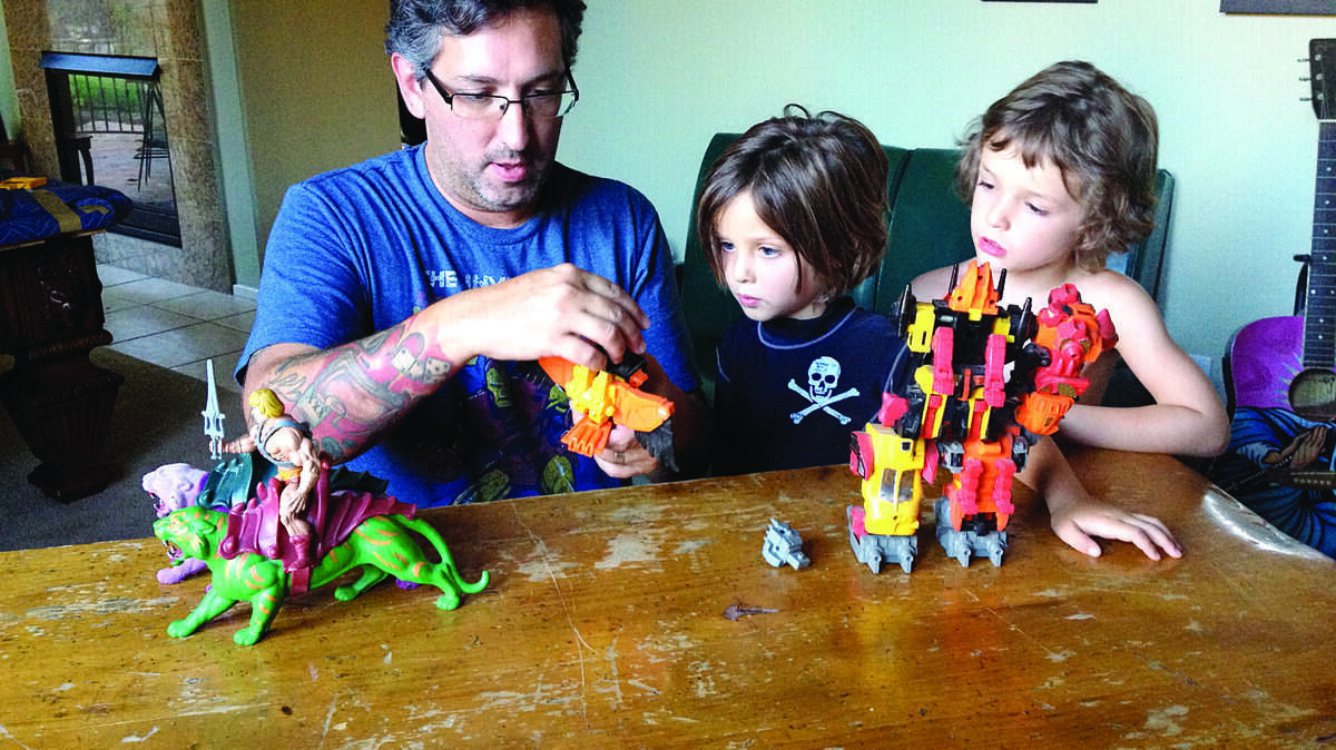 David Vienna shows his sons Wyatt, center, and Boone, right, how to transform one of his old childhood toys.