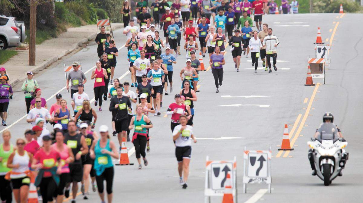 Runners head down Johnson Avenue under police escort April 22, 2012, in the inaugural San Luis Obispo Marathon.