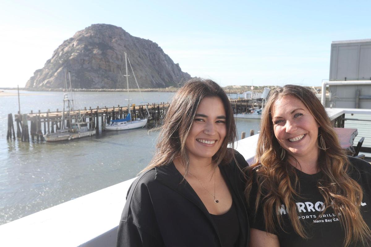 Two of the three partners at Morro Grill in Morro Bay on left, Kristien Ryder and Sharruss “Shay” Humlicek, take a quick break on the busy eatery’s second-story deck on Feb. 9, 2024.