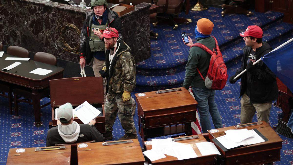 Protesters enter the Senate Chamber on Wednesday, Jan. 6, 2021 in Washington, D.C. Congress held a joint session today to ratify President-elect Joe Biden’s 306-232 Electoral College win over President Donald Trump. A group of Republican senators said they would reject the Electoral College votes of several states unless Congress appointed a commission to audit the election results. (Win McNamee/Getty Images/TNS)