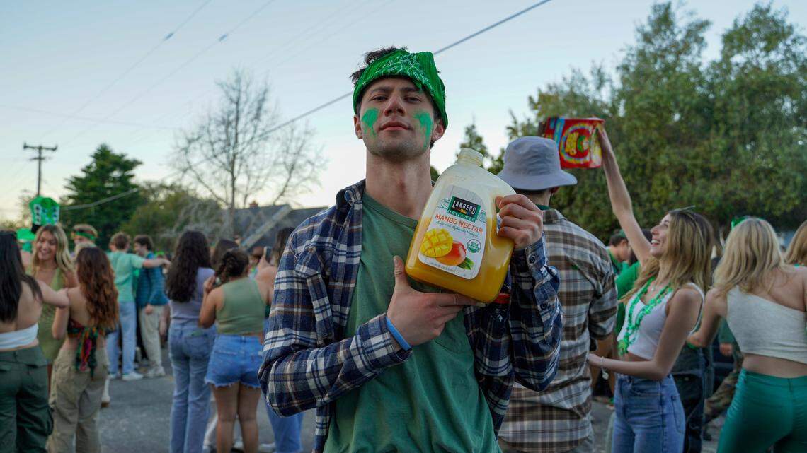 A Cal Poly student poses with a jug of juice Saturday morning, March 16, 2024, during St. Fratty’s Day festivities on Hathway Avenue near the university. A San Luis Obispo Police Department officer at the scene of the party estimated between 6,000 and 7,000 people in attendance.