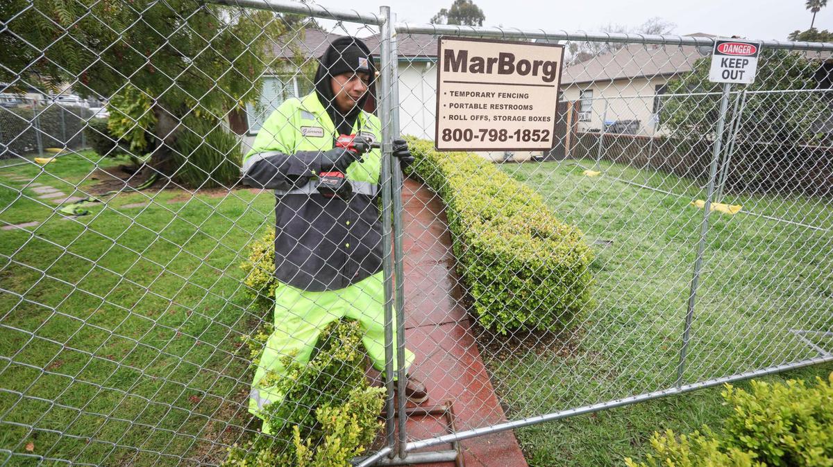 Marborg employee Bryan Gurrero installs a temporary fence on a house in the Hathway Avenue neighborhood on March 14, 2025, in advance of St. Fratty’s Day in San Luis Obispo.