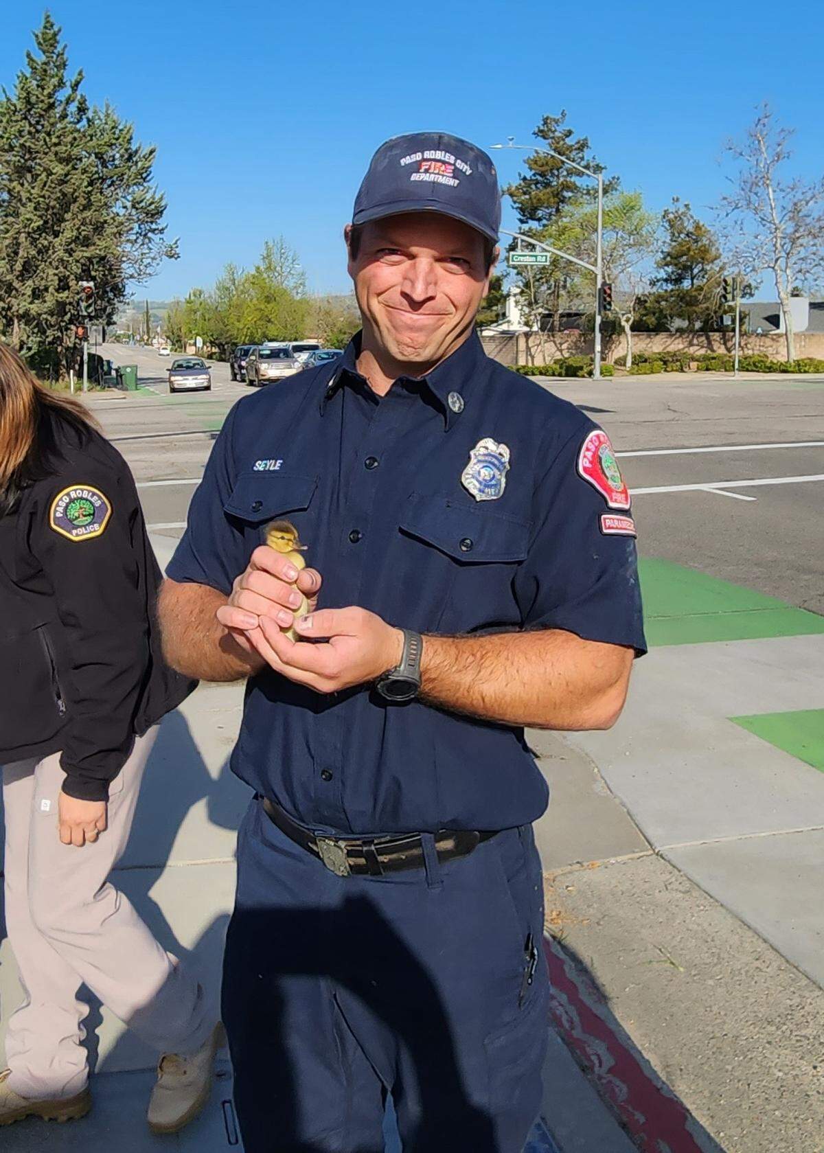 Paso Robles firefighter Christopher Seyle holds one of the 13 ducklings he rescued from a storm drain at Niblick and Creston roads on April 13, 2023.