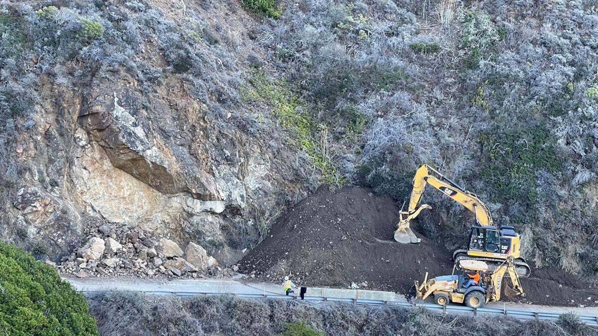 An excavator helps create a dirt ramp up to a large rock outcropping on Highway 1 on Thursday, Oct. 28, 2021. The highway will remain closed through Wednesday between Ragged Point and Gorda.