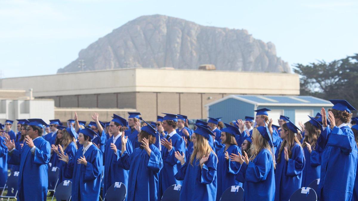 Students show silent applause for two students who are noise sensitive and who graduated first during the ceremony. Morro Bay High School held graduation ceremony at the football stadium June 9, 2022.