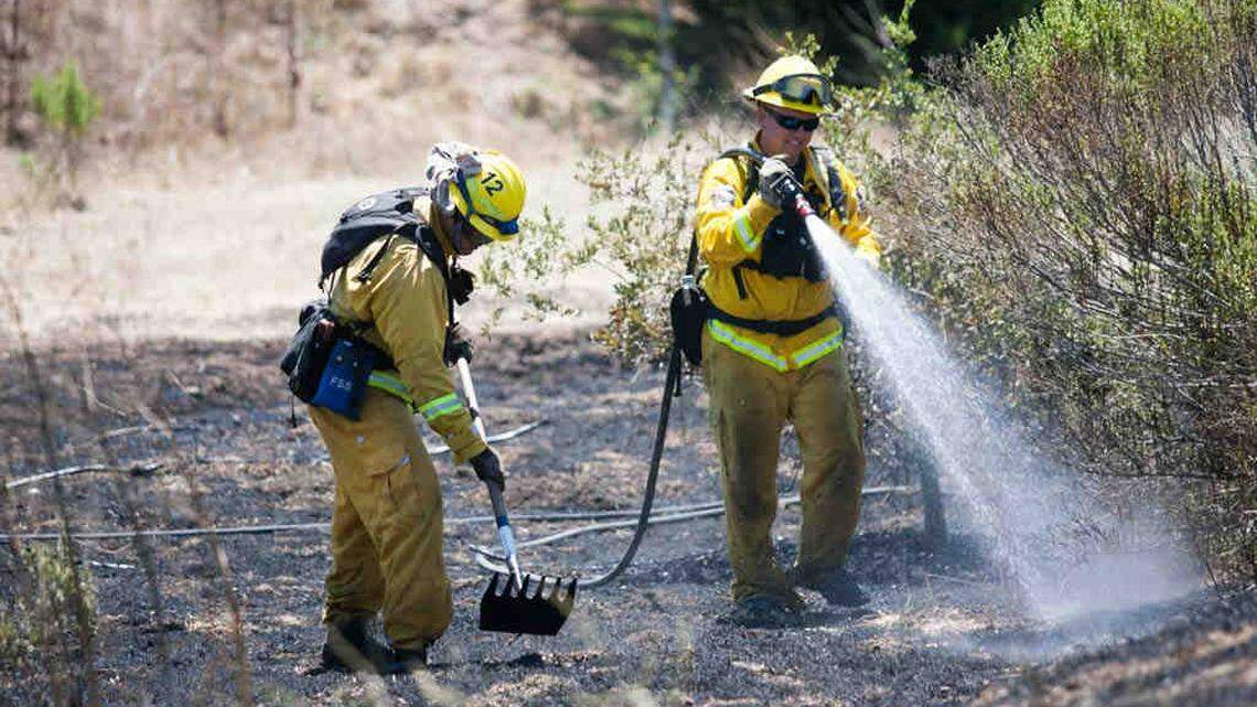 A fire that scorched a half acre was quickly put out by Cal Fire and San Luis Obispo City Fire Department firefighters. The fire was behind the Laureate school near O'Connor Way. Cal Fire Station 12 firefighters, Torrey Lepp, and Walter Aranda apply water and shovel  some smoldering areas.