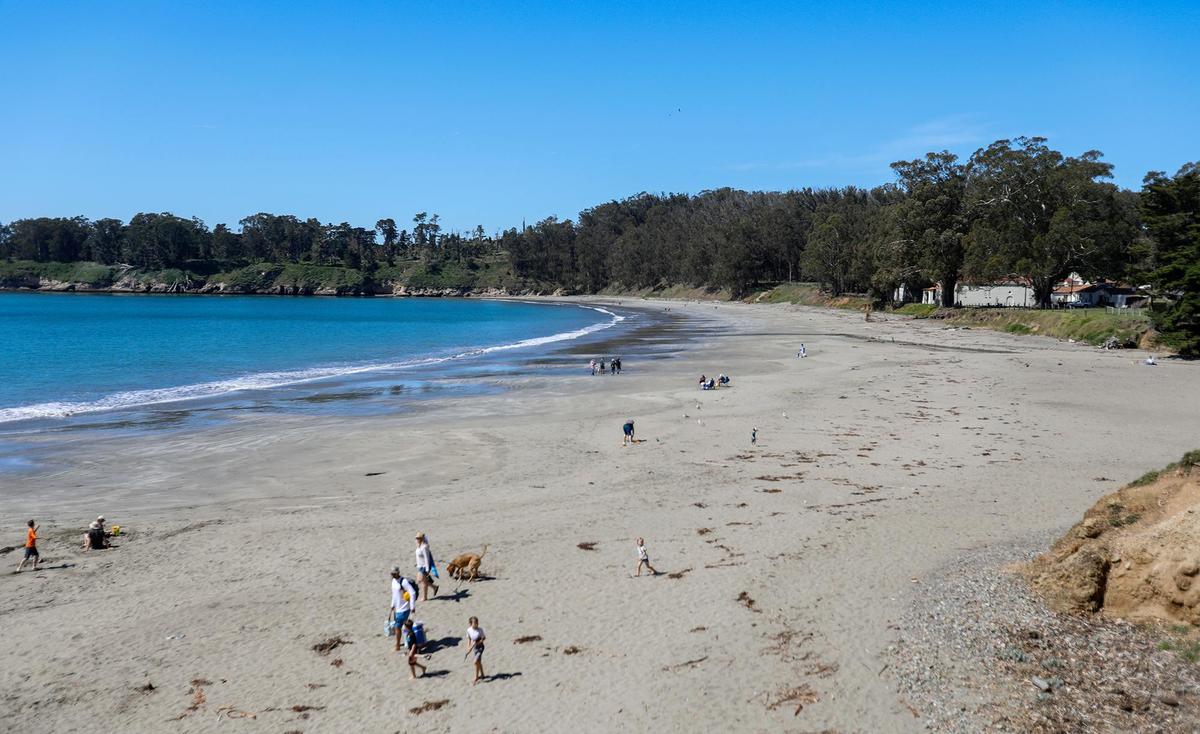 Visitors stroll on the sand Tuesday at William Randolph Hearst Memorial State Beach in San Simeon.
