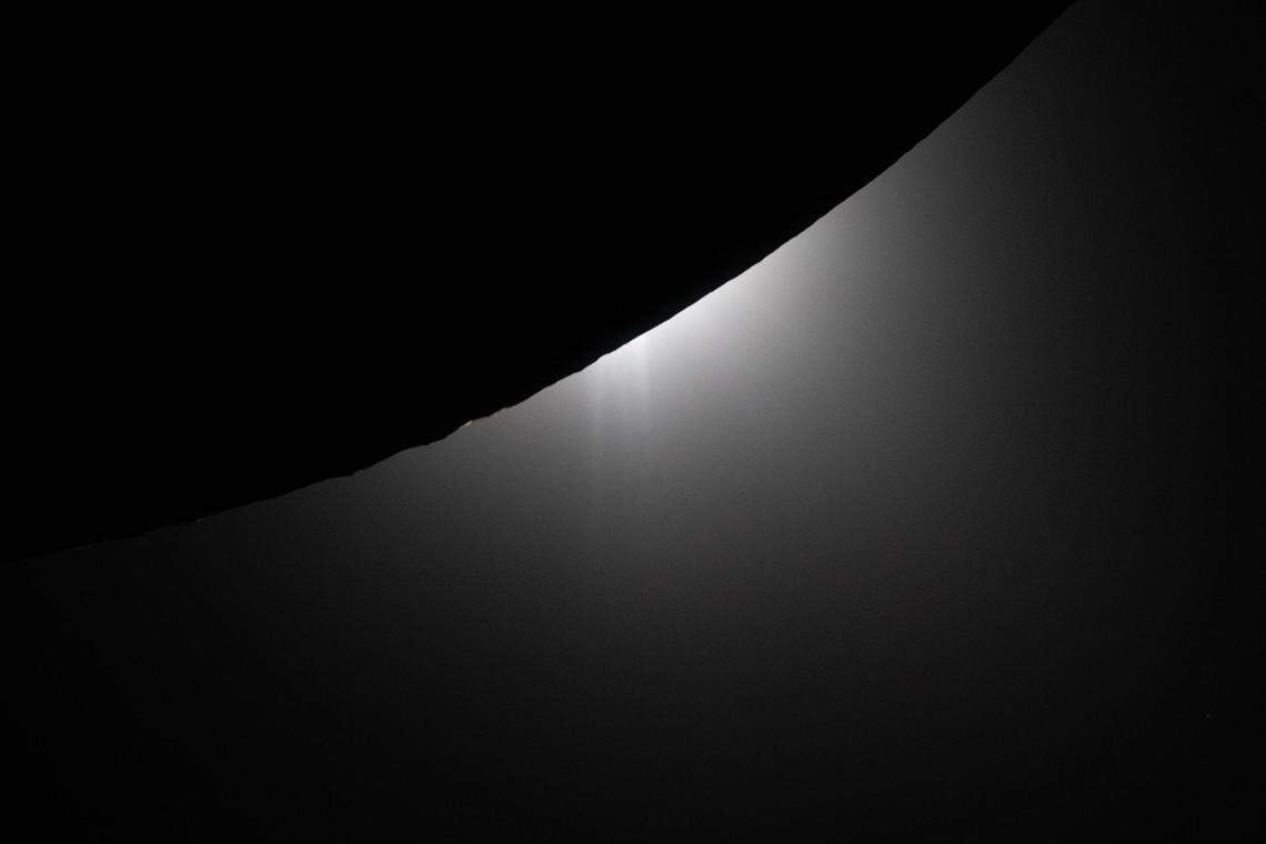 In this view captured by the Artemis II crew on the Orion spacecraft, a wedge of the moon in nighttime is visible in the foreground, as the sun sets on the opposite side. This image captures the beginning of a total solar eclipse that astronauts were able to observe at the end of their lunar observation period during Orion’s closest approach to the moon on April 6, 2026.