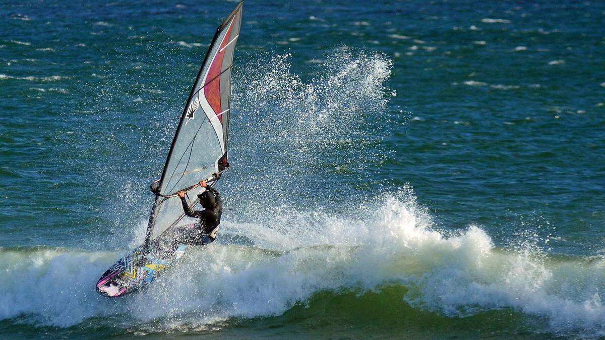 A windsurfer cuts through the waves near San Simeon.