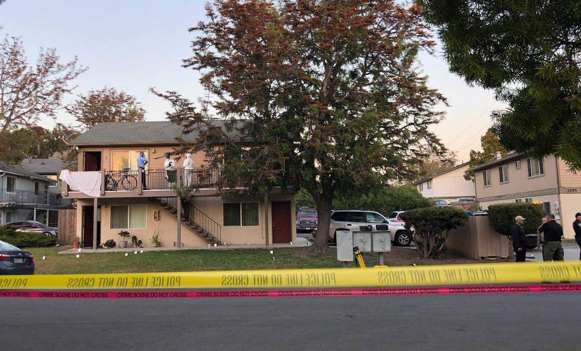 Police investigate the scene of Monday’s shooting in San Luis Obispo. Two police officers were shot and a suspect is dead. Police hung a sheet over the railing, blocking view of the doorway.