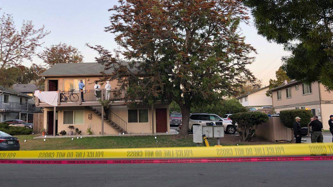 Police investigate the scene of Monday’s shooting in San Luis Obispo. Two police officers were shot and a suspect is dead. Police hung a sheet over the railing, blocking view of the doorway.