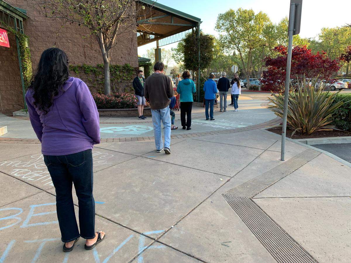 Trader Joe’s customers line up socially distanced outside the San Luis Obispo store during the COVID-19 pandemic in April 2020.