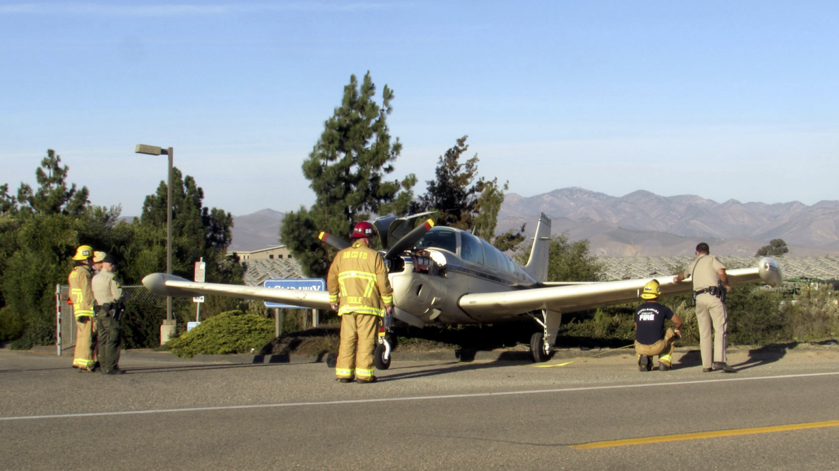 A small plane sits on the side of East Clark Avenue east of Orcutt on Saturday, Oct. 29, 2022, as Santa Barbara County firefighters gather measurements.