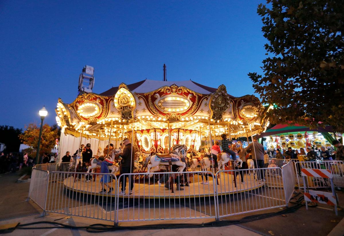 A brightly-lit carousel is packed with children during the Atascadero Fall Festival on Saturday, Nov. 19, 2022. The festival returned to the Sunken Gardens with carnival rides, games, live music, food and beer.