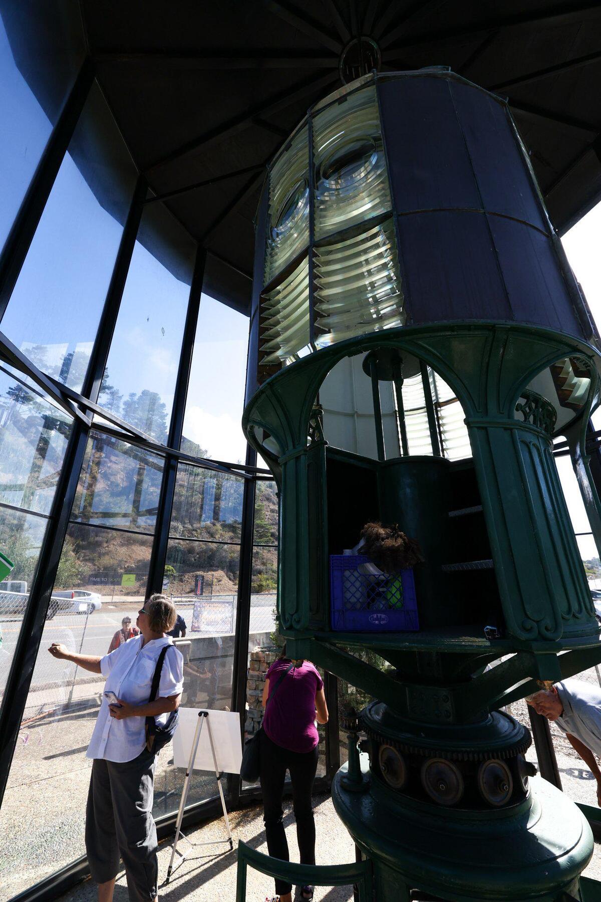 Coast Guard Curator Arlyn Danielson looks at the deteriorating protective structure around the Piedras Blancas Light Station’s historic First Order lens in Cambria, during a tour on Sept. 20, 2022.