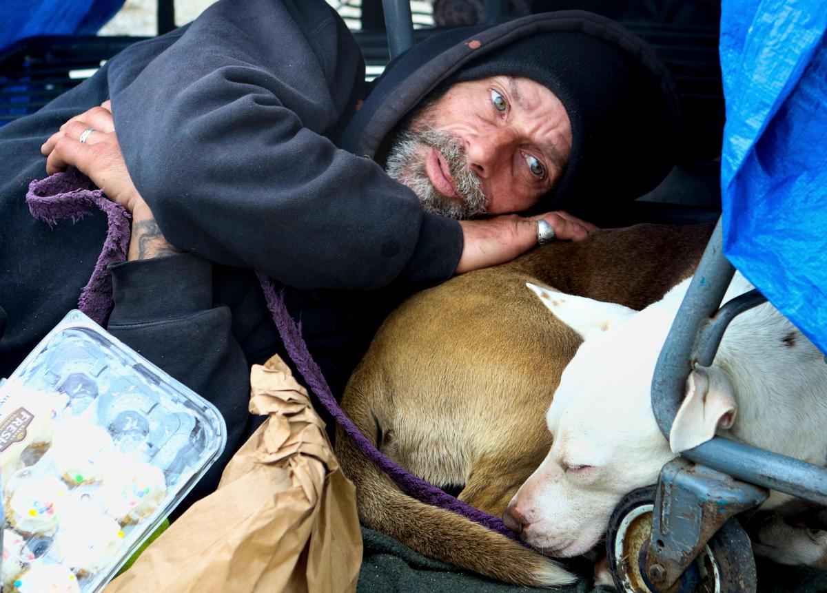 Michael Levesque and his dog, Gracy, rest under tarps stretched over shopping carts in this March 2020 photo. He prefers to live outside the 40 Prado Homeless Services Center shelter in San Luis Obispo.