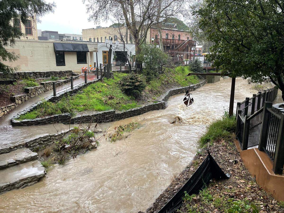 San Luis Obispo Creek in downtown San Luis Obispo is swollen with rainwater on Tuesday, March 14, 2023, as a major rain storm sweeps through the Central Coast.