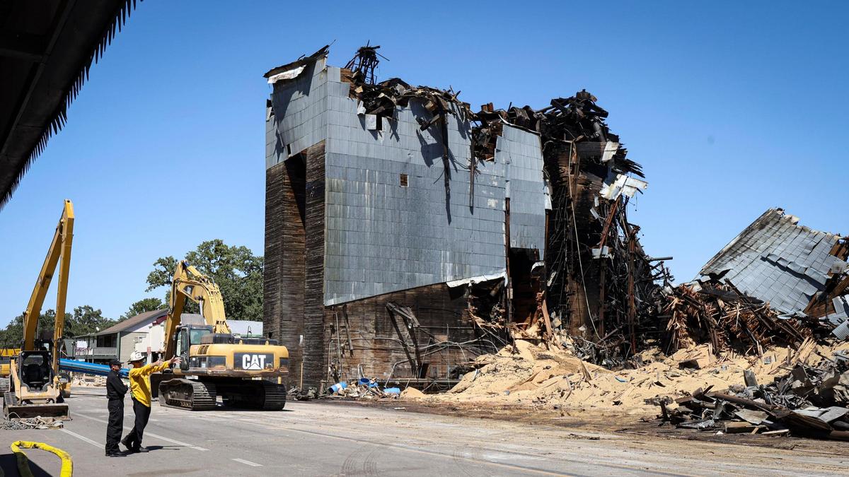 Grain and charred timbers spill from fire damaged silos as demolition work continued of the landmark Templeton Feed & Grain building on July 7, 2025. The historic building burned in a fire that sparked in the late night hours of July 4.