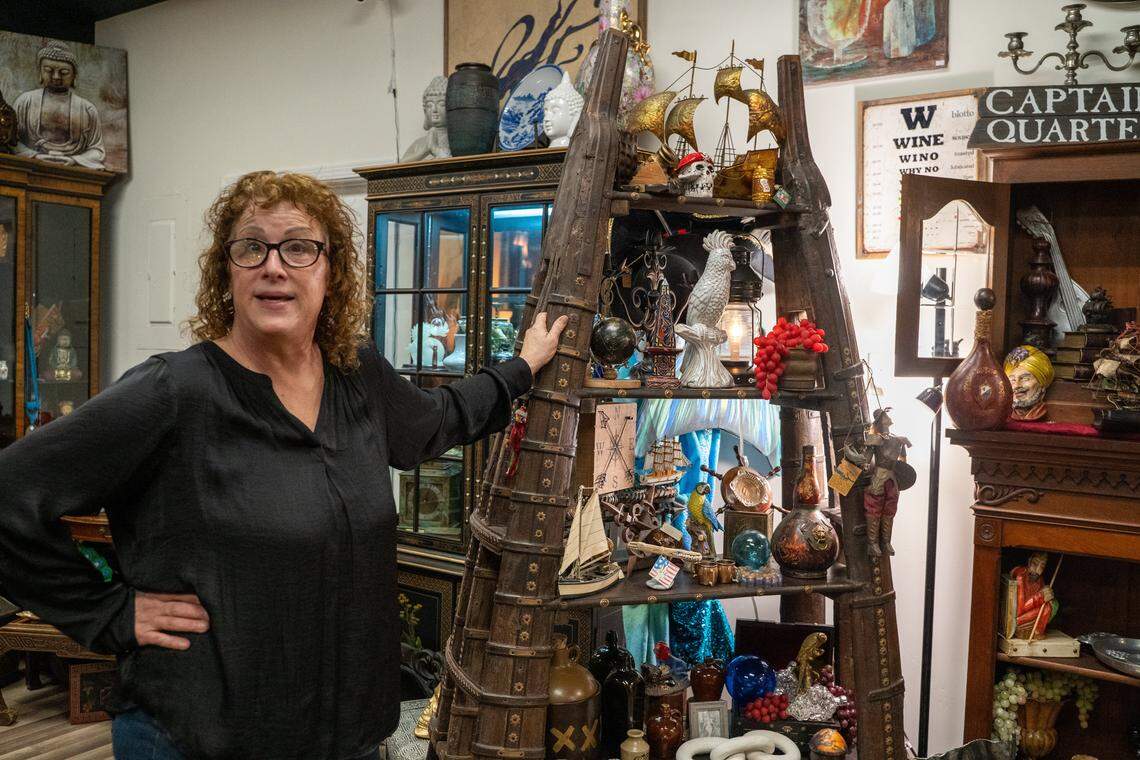 Odd Fellows Antiques Emporium owner Shalee Robinson stands near a display of items for sale on Tuesday, Nov. 11, 2025. The antique store moved to 1527 W Grand Ave. in August after its 983 W Grand Ave. home was sold to new owners.