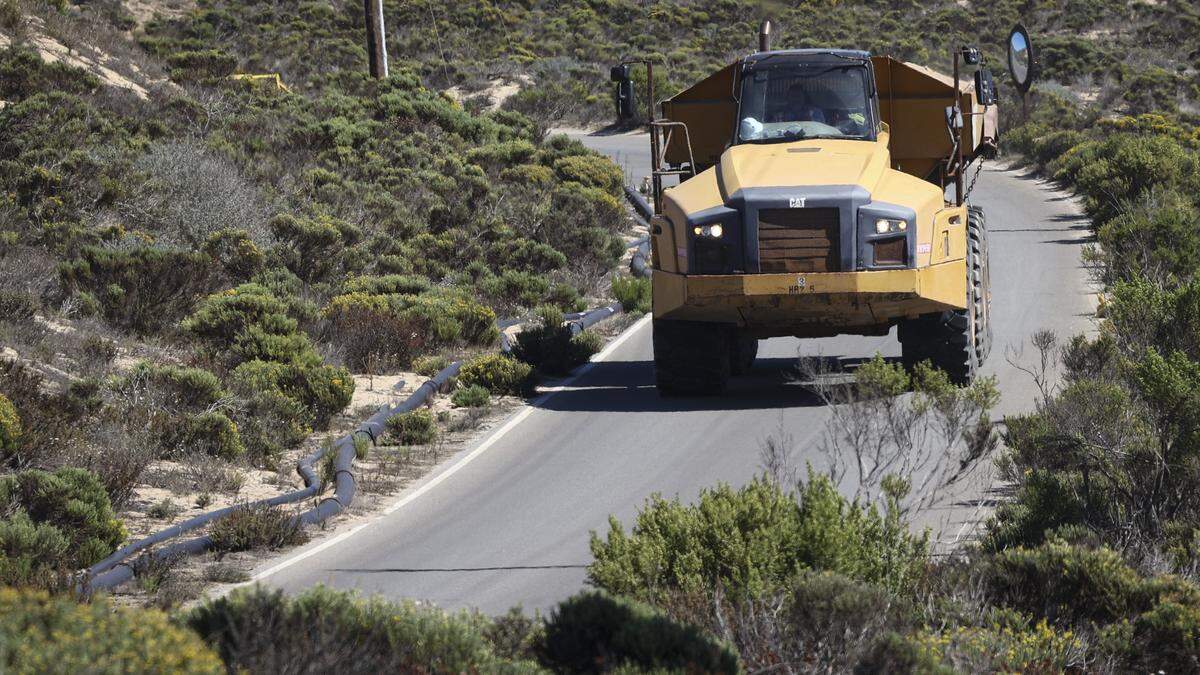 Earth-moving dump trucks navigate the narrow roads of the former Unocal oil field as part of cleanup work at the Guadalupe-Nipomo Dunes on Oct. 1, 2025. Chevron agreed to donate the property to the U.S. Fish and Wildlife Service when the remediation is complete.