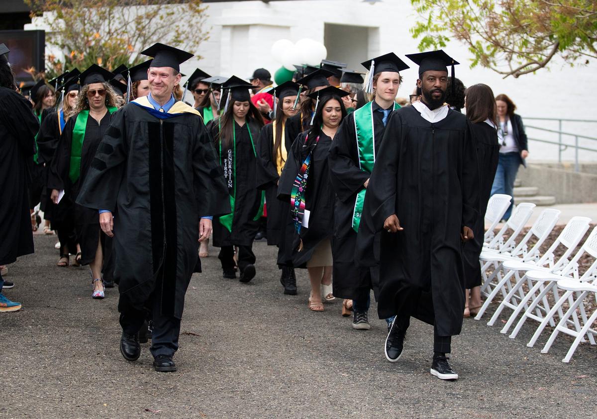 Cuesta College held its 59th commencement ceremony at the San Luis Obispo campus on Friday, May 17, 2024. Cuesta College philosophy professor Chris Gilbert, left, leads the way at the start of the commencement ceremony.