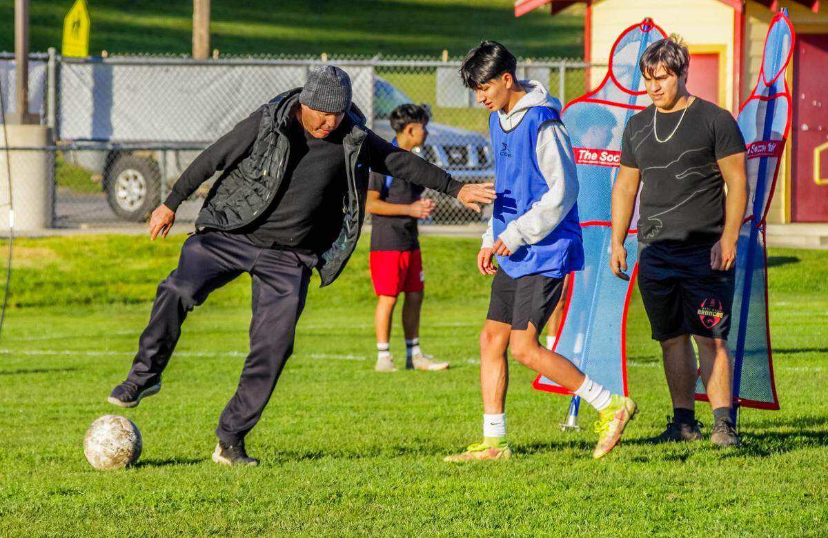 Coast Union High School head soccer coach Luis Plasencia tutors Diego Gomez, in blue, and Adair Ponce, wearing black, during the 2022-2023 season.