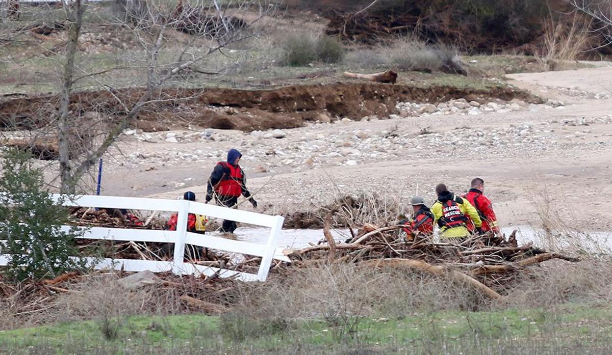 Searchers check through floodwaters for any sign of 5-year-old Kyle Doan on Wednesday, Jan. 11, 2023, two days after he disappeared in swollen San Marcos Creek near San Miguel.