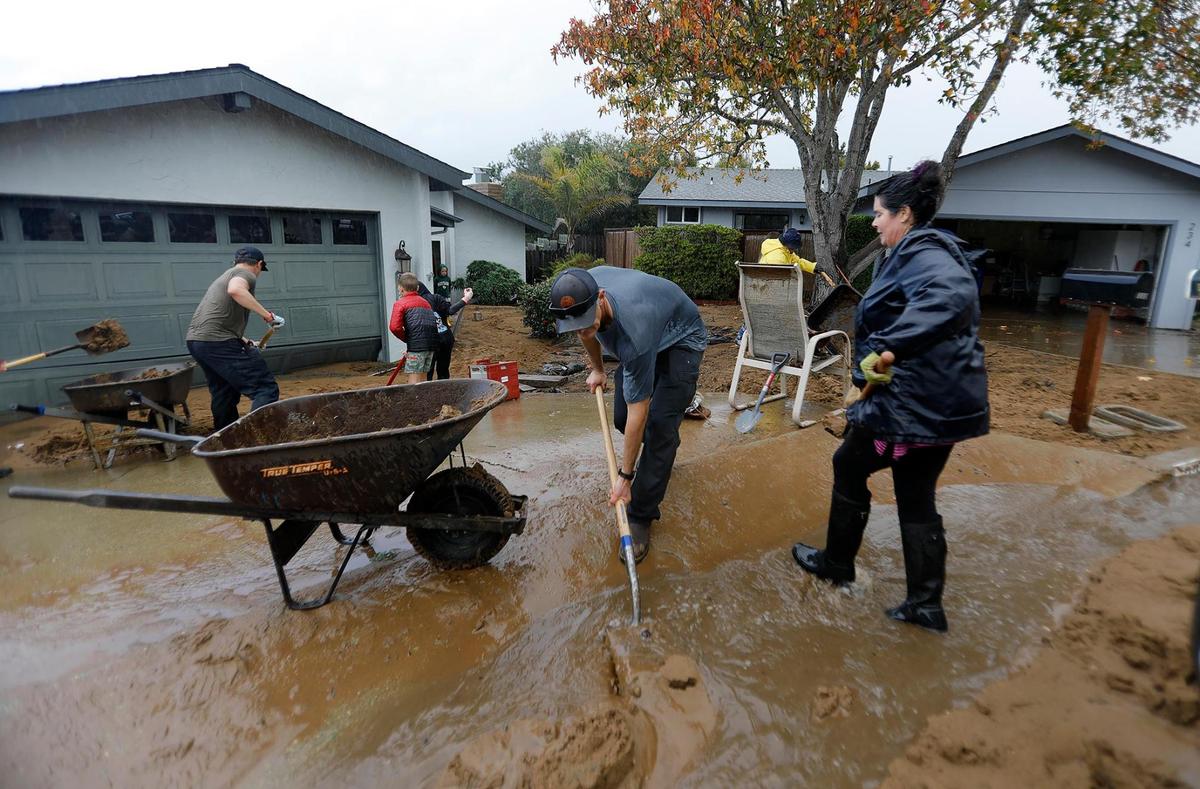 Los Osos residents turned out Tuesday, Jan. 10, 2023, to help clean up mud and debris that hit homes on Vista Court when a water retention basin failed and sent a torrent of floodwater pouring down onto the neighborhood from the hillside above.