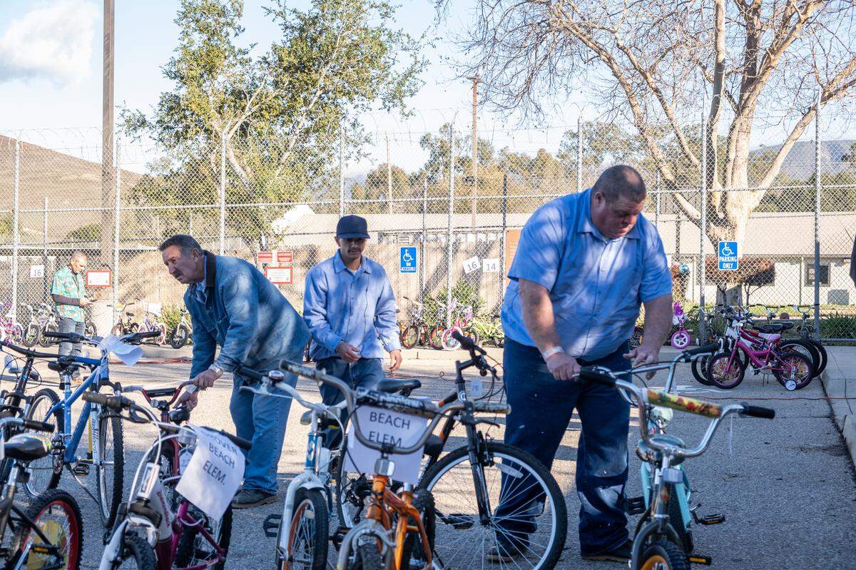 San Luis Obispo County Jail inmates help move bikes during the San Luis Obispo County Sheriff’s Office bicycle giveaway on Dec. 13, 2022. The program teaches inmates how to repair bikes, and those bikes are given to low-income families in the county.