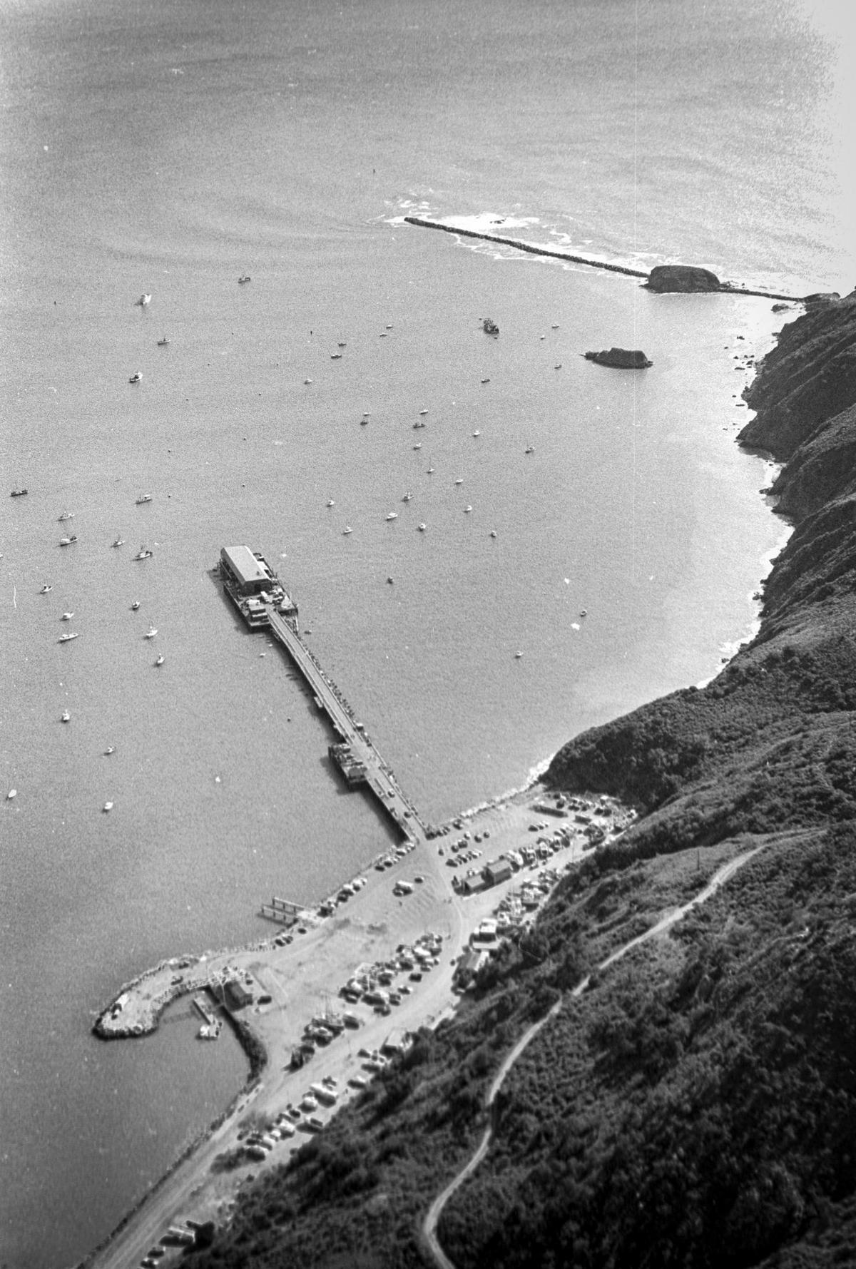 Harford Pier and the Port San Luis parking lot in a historic aerial view. The pier construction dates back to 1869 and it once was the terminus of the Pacific Coast Railway connecting the region to steam ships. Reporter Brooks Townes took a flight over coastal areas from Morro Bay to Avila Beach on Feb. 22, 1984.