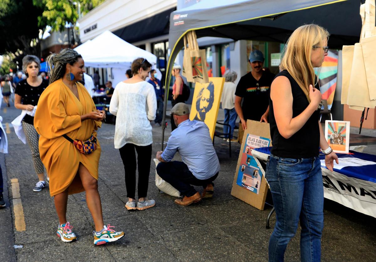 Courtney Haile of R.A.C.E. Matters oversees a display booth the group had on Morro Street at a recent Downtown SLO Farmer’s Market in San Luis Obispo.