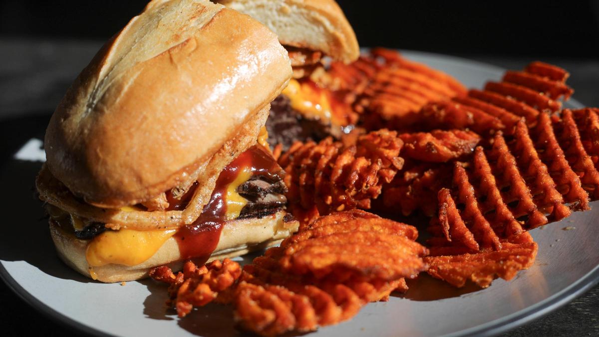 The Western tri tip sandwich at the new Morro Grill on the Embarcadero includes thin-sliced tri-tip steak, cheddar cheese, onion strings and house-made barbecue sauce on toasted garlic bread, with lightly seasoned sweet-potato waffle fries on Feb. 9, 2024.
