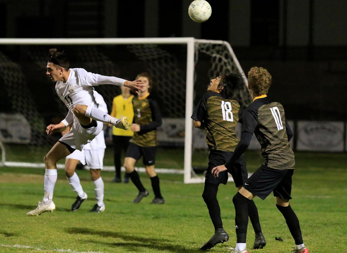 Arroyo Grande’s Tyler Brittingham (11) heads the ball as SLO High School’s Kellan Barry (10) and Eduardo Torres (18) watch. Arroyo Grande High School and San Luis Obispo High School competed Thursday in a CIF Central Section boys soccer match at SLO High School.