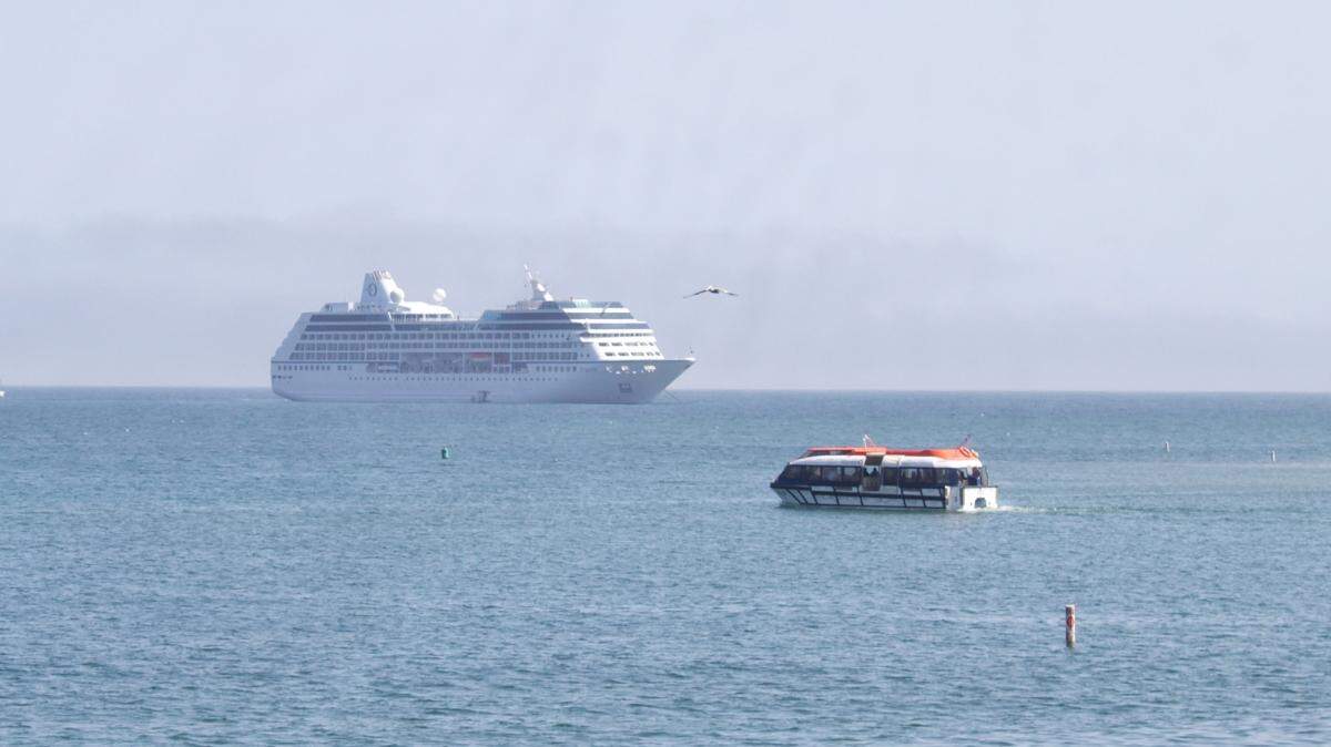 A ship’s tender, right, transports cruise ship passengers back to the MS Regatta, which was anchored offshore from Santa Barbara on May 2, 2022.