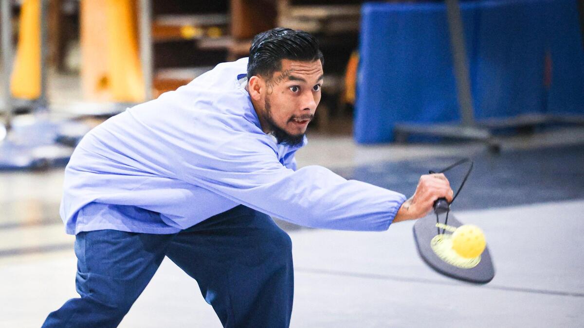 California Men’s Colony inmate Alejandro Quiroz uses an unconventional grip to put spin on the pickleball. A coach visited the San Luis Obispo prison on Nov. 12, 2024, to teach them the game, which is growing in popularity at facilities across the state.