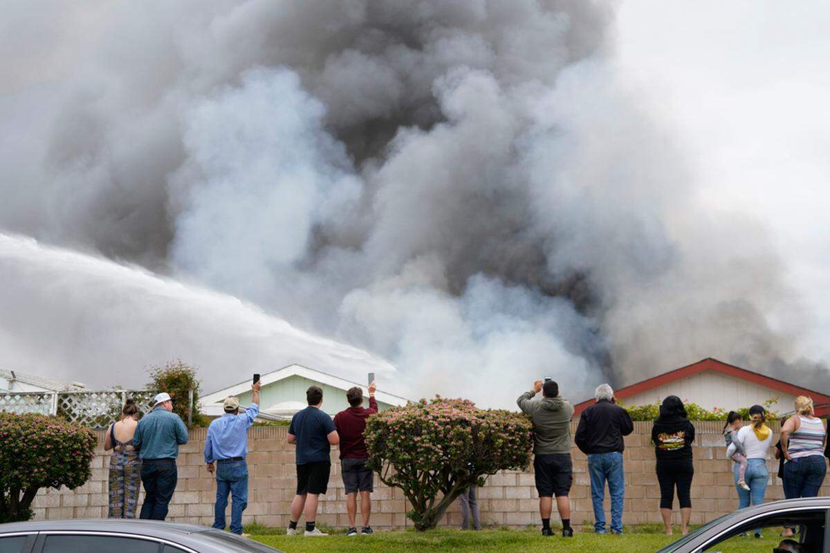 A crowd watches a mobile home burning on West Taylor Street in Santa Maria on Friday, June 21, 2019. Police say two people were found dead in Casa Grande Mobile Estates.