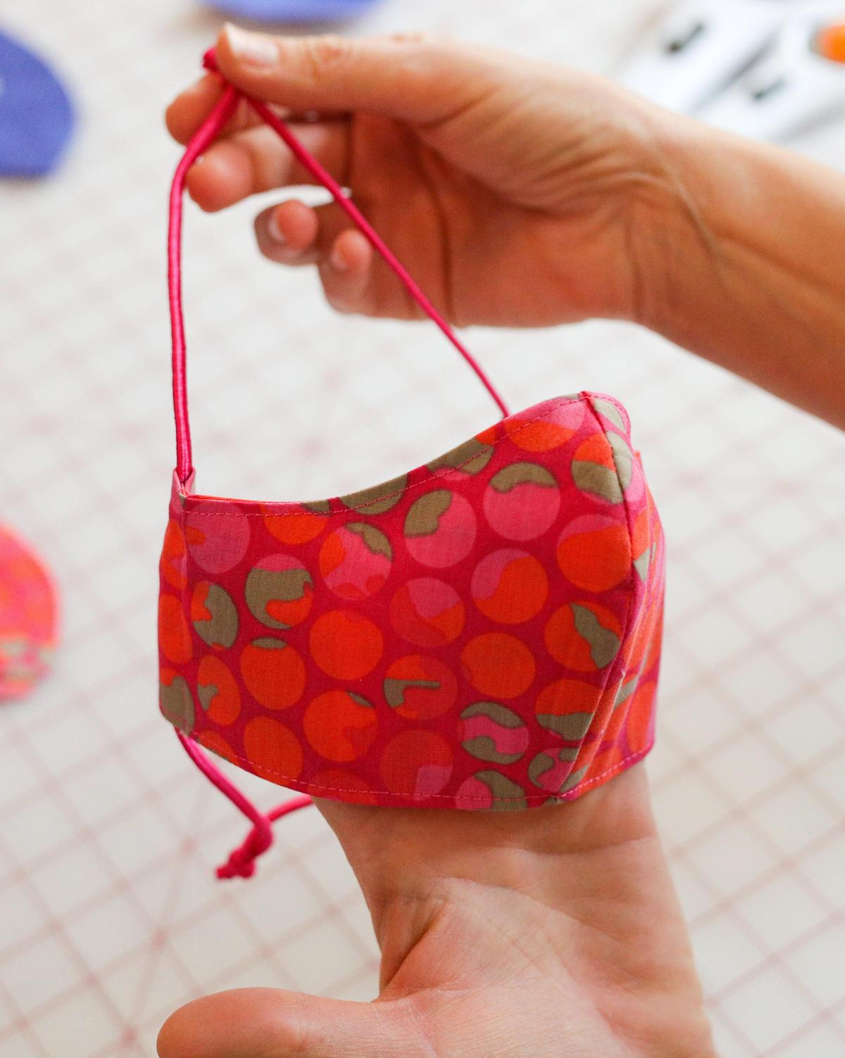 Stephanie Thomas displays one of the masks she sewed for patients at Wilshire Home Health.