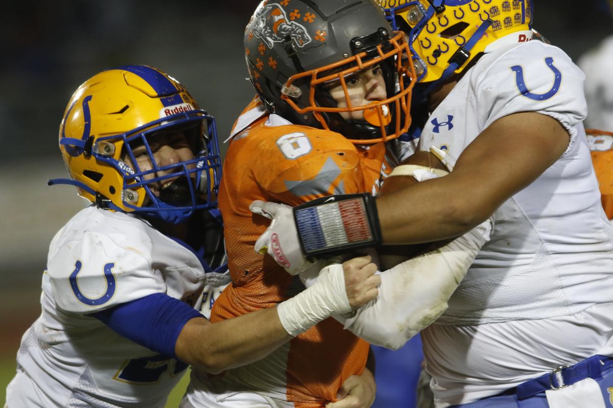 Greyhound Diego Real (6) gets squeezed by Dos Palos defensive linemen. Atascadero High School Greyhounds beat Dos Palos Broncos 35-0 in the prep football semifinals, Friday, Nov. 18, 2022.