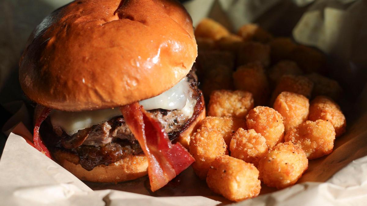 Mushroom Swiss Burger — freshly pressed 6-ounce chuck beef patty cooked medium, caramelized onions, sautéed mushrooms, bacon, garlic aioli and Swiss cheese on brioche bun, with tater tots on the side, at Morro Grill in Morro Bay on Feb. 9, 2024.