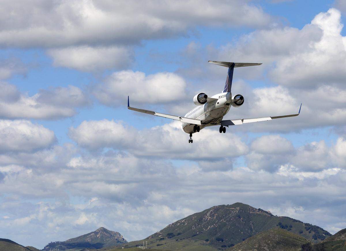 A United Airlines jet flies over San Luis Obispo County Regional Airport.